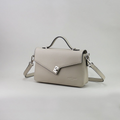 Maža šviesiai pilka natūralios odos moteriška rankinė iš prancūzų gamintojo kolekcijos, su užtrauktuku ir papildoma sagtele, nugarine užtrauktuku užsegama kišene, ilga reguliuojama rankena per petį ir trumpa rankena nešiojimui rankoje, sidabro spalvos furnitūra, elegantiška ir universali miesto rankinė
