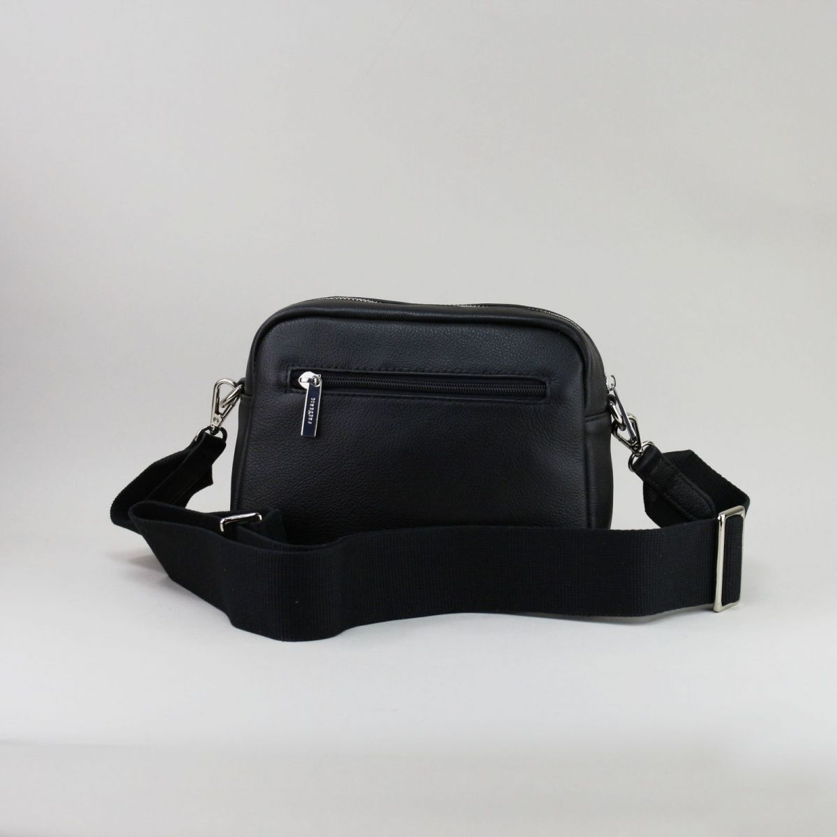 Back view of black leather handbag with rear zip pocket and elegant finish.
uodos odinės rankinės nugarinė pusė su užtrauktuku ir elegantiška apdaila