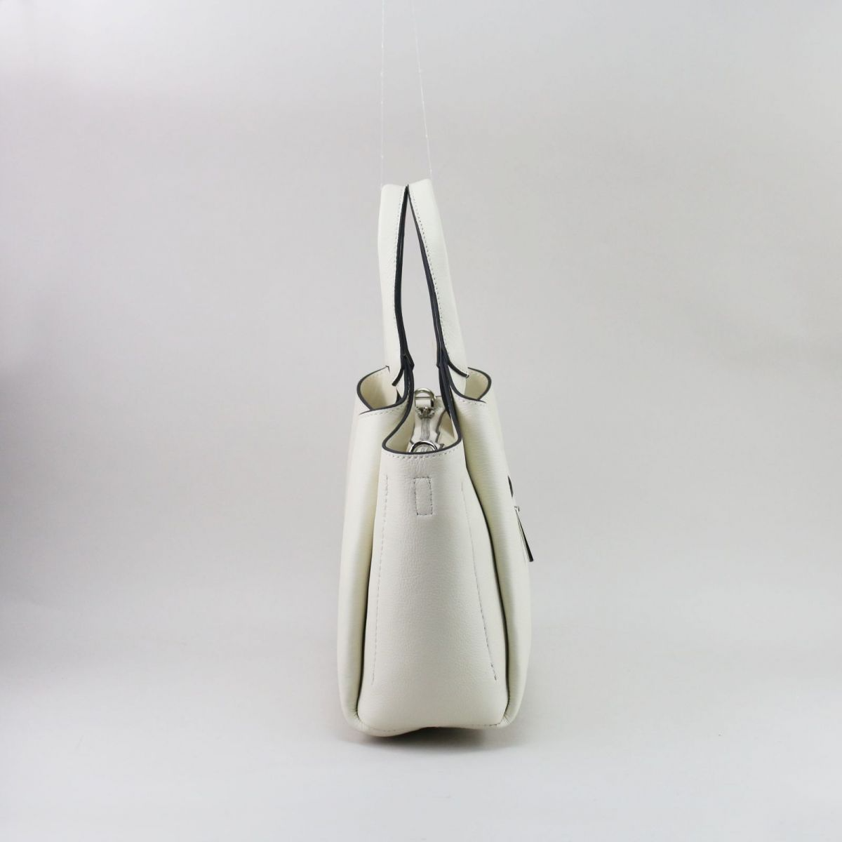 Creamy white genuine leather handbag with silver hardware, featuring three separate compartments (middle with zip closure), two inner pockets including one zippered, and a rear external zip pocket. Comes with short top handles and a detachable adjustable strap for shoulder or crossbody wear. | Šiltai balta natūralios odos rankinė su sidabrine furnitūra, 3 skyriais ir universaliu dizainu – elegancija kasdienai.