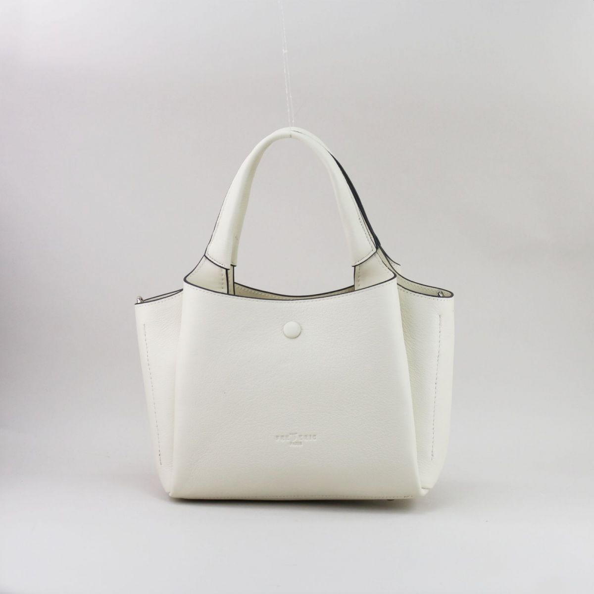 Creamy white genuine leather handbag with silver hardware, featuring three separate compartments (middle with zip closure), two inner pockets including one zippered, and a rear external zip pocket. Comes with short top handles and a detachable adjustable strap for shoulder or crossbody wear. | Šiltai balta natūralios odos rankinė su sidabrine furnitūra, 3 skyriais ir universaliu dizainu – elegancija kasdienai.