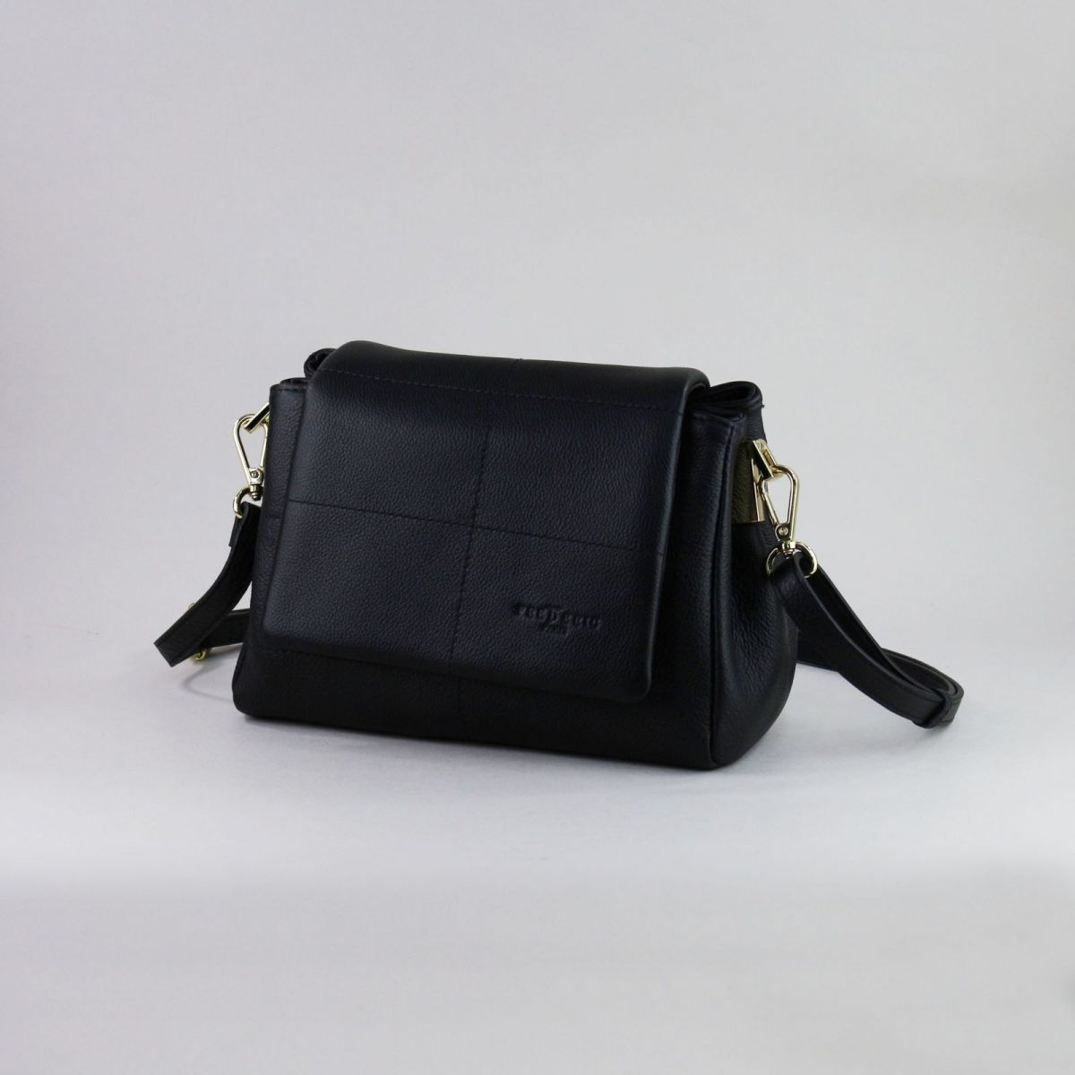 Black genuine leather handbag made by a reputable French manufacturer, featuring a structured flap closure, gold-tone hardware, rear zip pocket, and adjustable shoulder strap up to 115 cm. Elegant, compact, and timeless – a perfect accessory for daily use or evening outings. | Juoda natūralios odos rankinė, sukurta patikimo prancūzų gamintojo – su atvartu, auksine furnitūra ir reguliuojamu dirželiu – mėgstamas pasirinkimas stilingai moteriai.