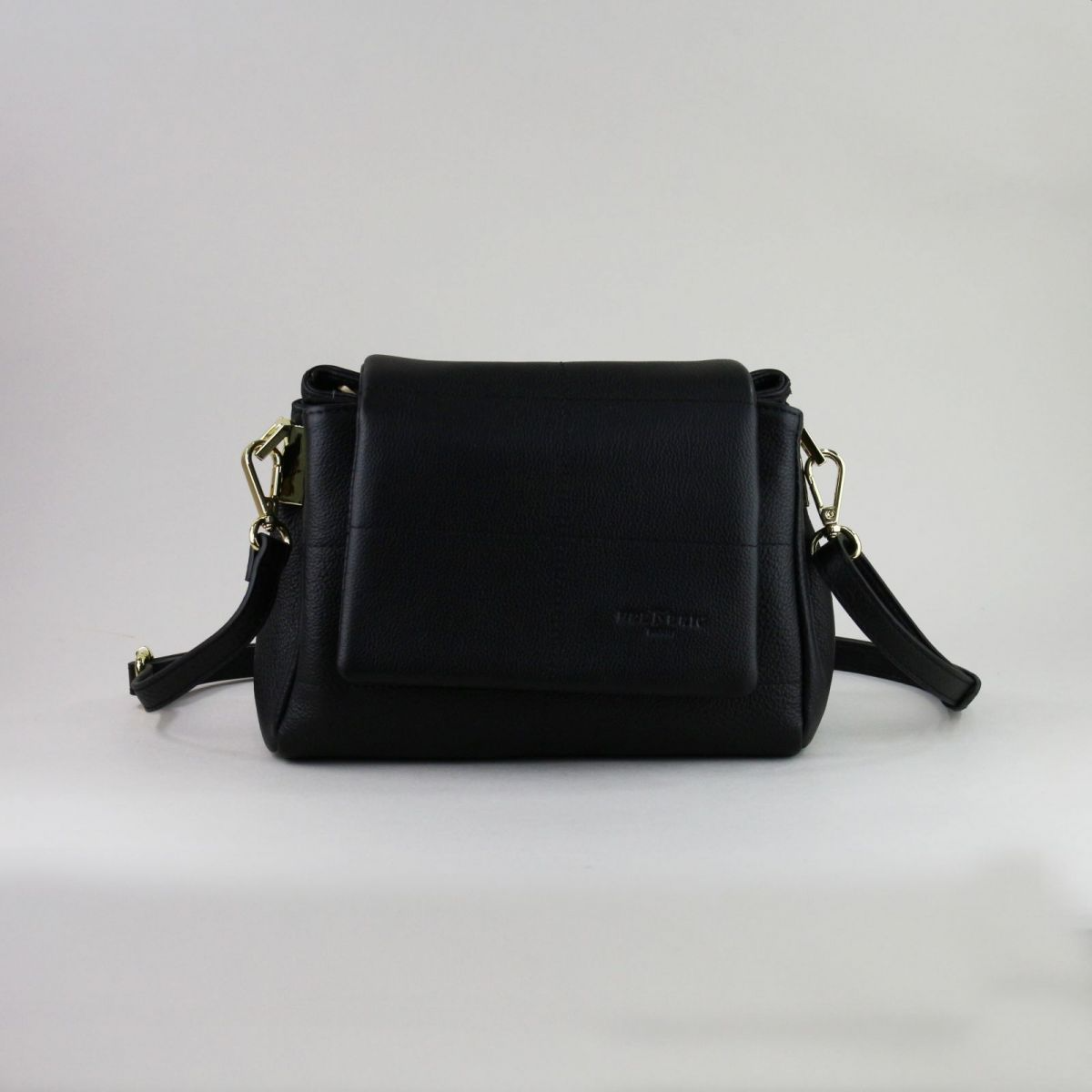 Black genuine leather handbag made by a reputable French manufacturer, featuring a structured flap closure, gold-tone hardware, rear zip pocket, and adjustable shoulder strap up to 115 cm. Elegant, compact, and timeless – a perfect accessory for daily use or evening outings. | Juoda natūralios odos rankinė, sukurta patikimo prancūzų gamintojo – su atvartu, auksine furnitūra ir reguliuojamu dirželiu – mėgstamas pasirinkimas stilingai moteriai.