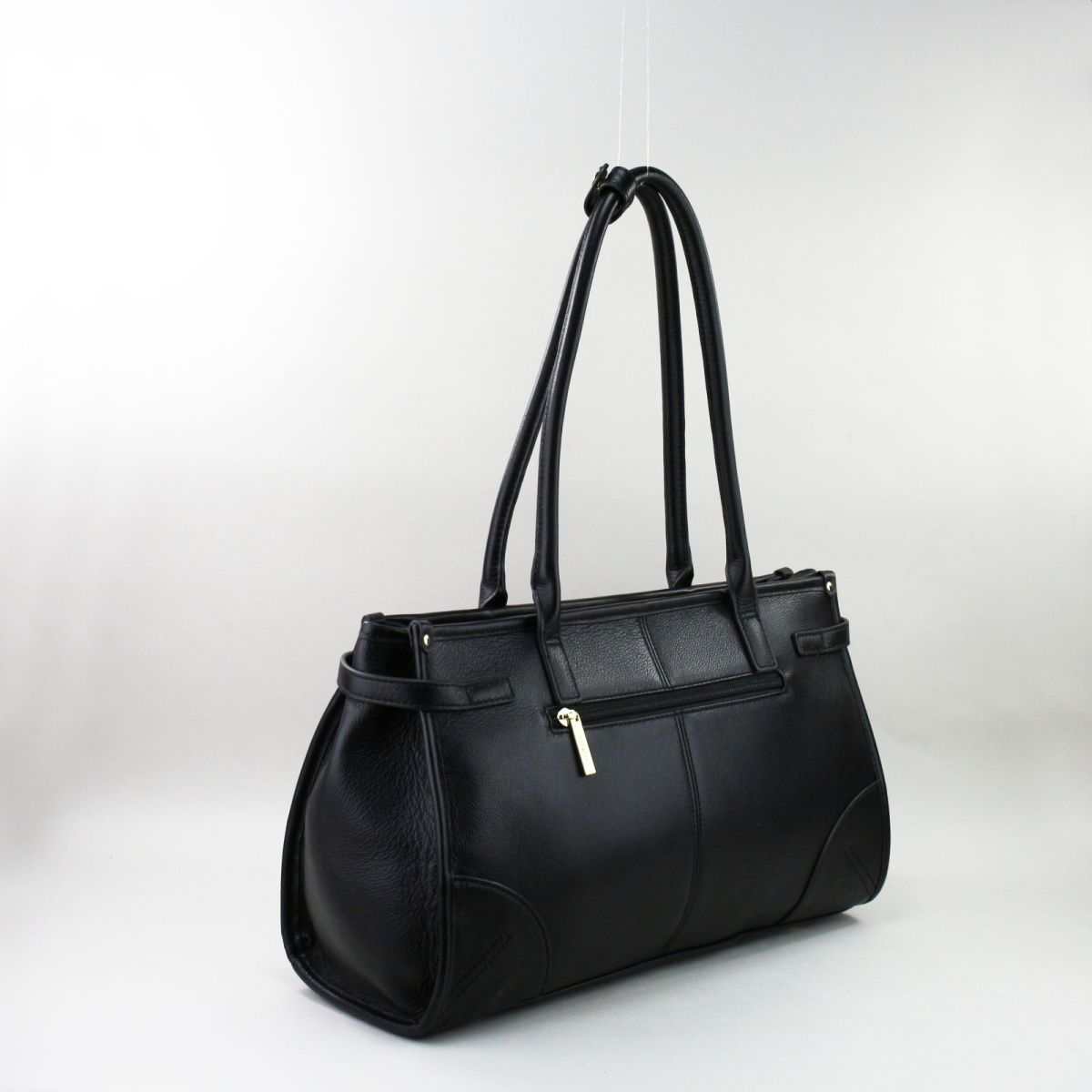 Elegant black genuine leather handbag from a new French collection, featuring long shoulder handles, golden hardware, a decorative belt detail, and a zipped back pocket. Ideal for everyday elegance and work or casual use. Juoda natūralios odos rankinė iš naujos kolekcijos – ilgos rankenos, auksinės detalės, klasikinis dizainas.