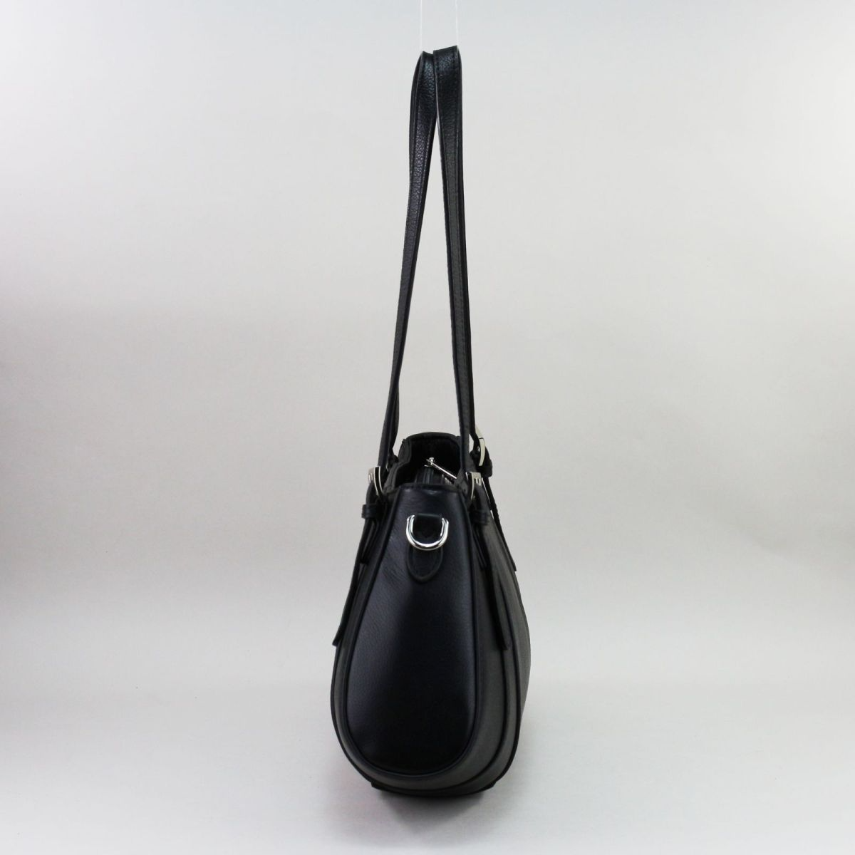 Black genuine leather handbag by Frederic T. with elongated shoulder handles, high-quality silver hardware, zip closure, spacious main compartment, three inner pockets (two with zippers), and a rear exterior zip pocket. Comes with an adjustable, removable strap for versatile wear – on the shoulder or crossbody. Classic, functional, and elegant. | Juoda natūralios odos rankinė su ilgomis rankenomis, užtrauktuku, funkcionali ir talpi, su kišenėlėmis viduje ir sidabrine furnitūra.