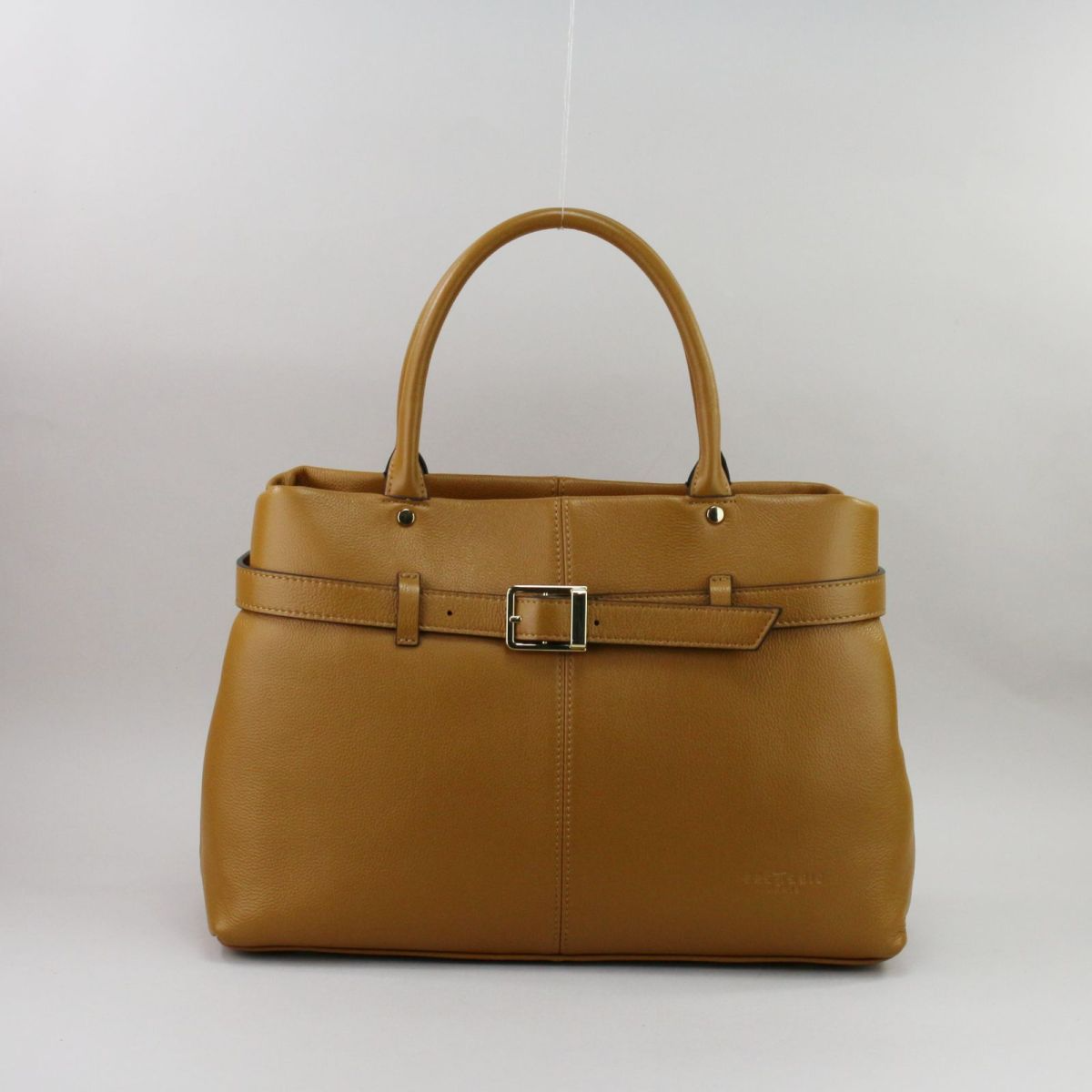 Camel color genuine leather handbag for women with elegant French design, short handles for shoulder wear, front buckle detail, and zip closure. Prancūziško dizaino natūralios odos rankinė moterims, šilta „camel“ spalva, dvigubos rankenos patogiam nešiojimui ant peties, užsegama užtrauktuku, priekyje dekoratyvinė sagtis.