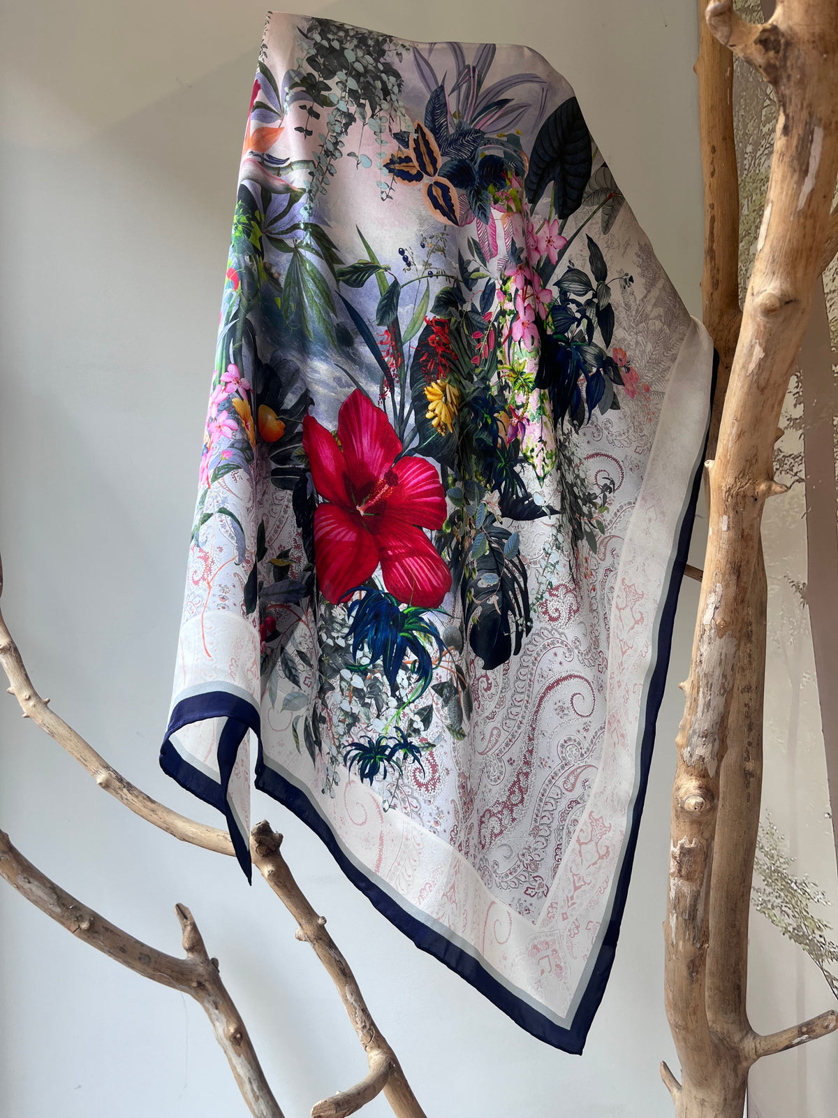 Luxury silk scarf for women 90x90 cm with floral print framed by dark border, elegant square silk scarf on light background, refined accessory for neck, hair or handbag, perfect gift, Elegantiška šilkinė skarelė moterims 90x90 cm su gėlių motyvu centre ir tamsia juostele aplink kraštus, prabangi kvadrato formos šilko skarelė ant šviesaus fono, rafinuotas aksesuaras kaklui, plaukams ar rankinei, subtili dovanos idėja moteriai.