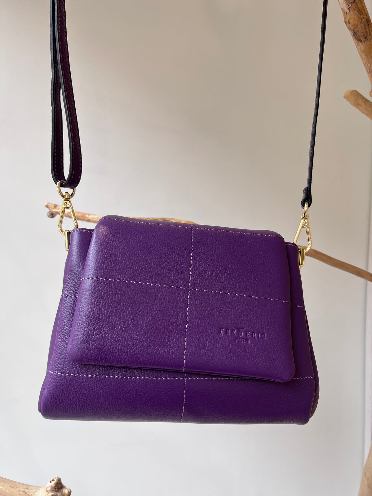 Violetinės spalvos elegantiška moteriška rankinė iš natūralios odos, su ilgu reguliuojamu ir nuimamu dirželiu, atvarto tipo užsegimu ir auksinės spalvos furnitūra. Rankinės nugarinėje pusėje yra išorinė kišenė su užtrauktuku, viduje – trys skyriai, iš kurių vidurinis užsegamas. Ši rankinė prancūziško dizaino, minimalistinio stiliaus, idealiai tinka nešioti tiek ant peties, tiek skersai per kūną – puikus pasirinkimas tiek kasdienai, tiek išeigai.
