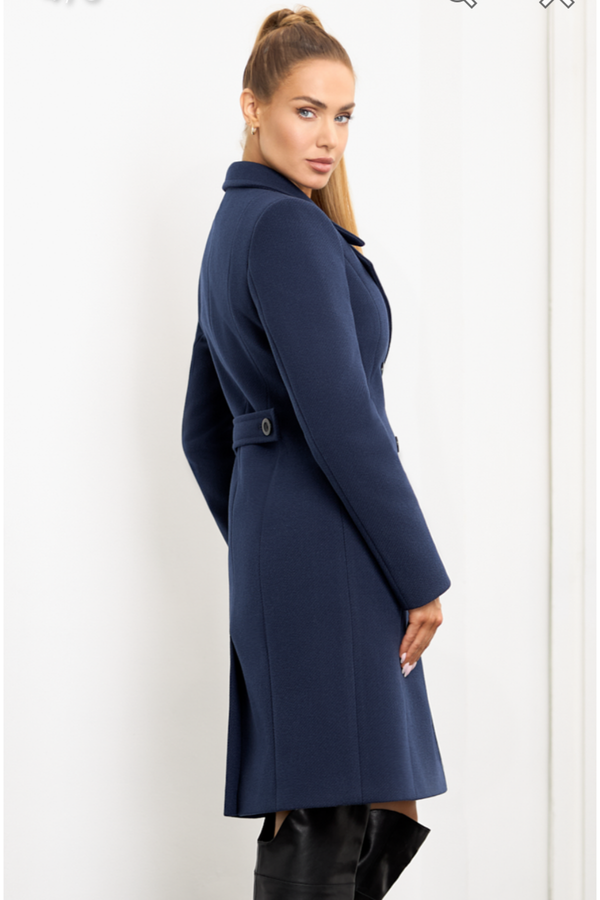 Navy blue wool coat Paris for women – elegant short knee-length coat with double-breasted buttons, wide lapel collar, back vent and decorative back tab. Insulated and lined, stylish and warm. Model is wearing size 34. Tamsiai mėlynas vilnonis paltas Paris – trumpas, klasikinis paltas su dvieile sagų eile ir nugara dekoruota patka.