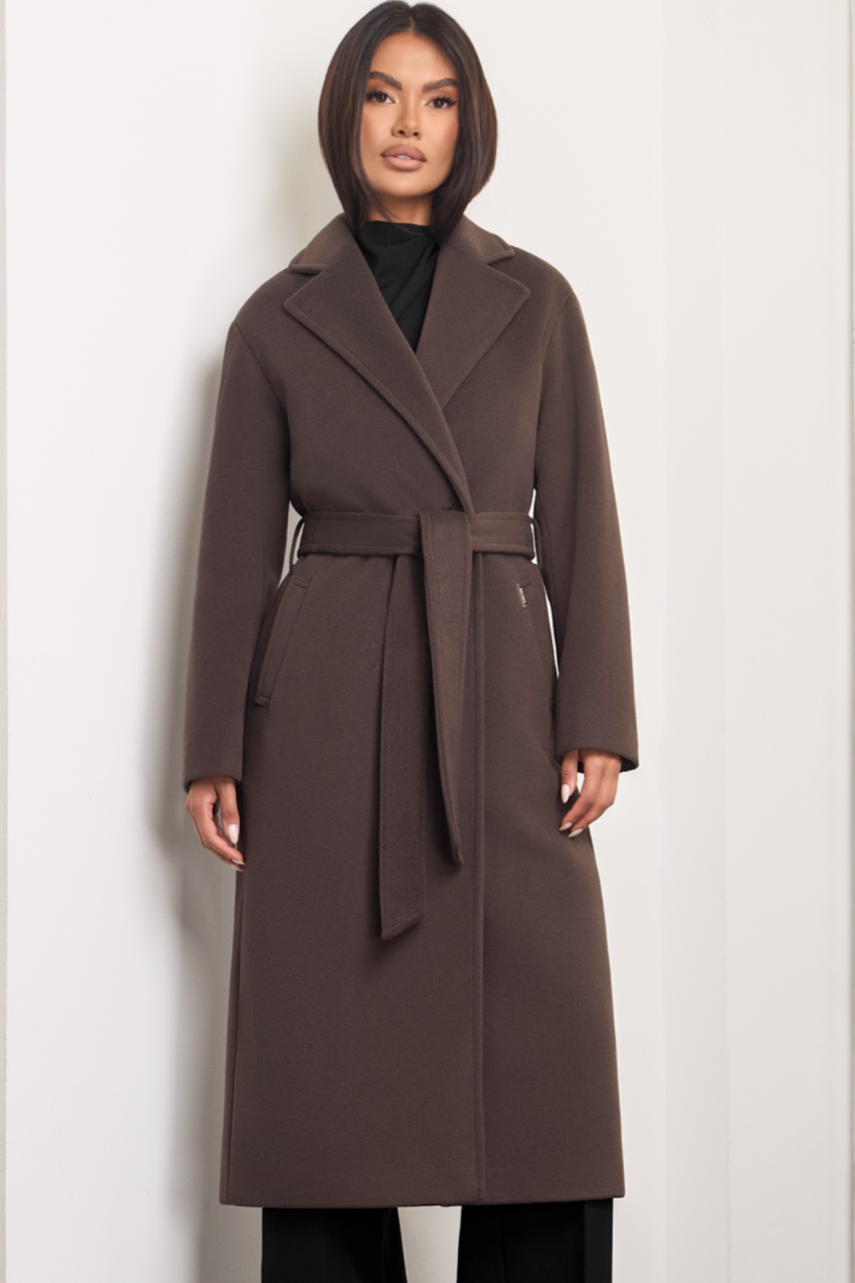 Brown wool coat Dakota for women – long elegant winter coat with wide lapels, belt at the waist, side pockets and dropped shoulders. Insulated and lined, warm and timeless. Model is wearing XS size. Rudas vilnonis paltas Dakota – ilgas, klasikinio silueto paltas su diržu, kišenėmis ir nuleistais pečiais.