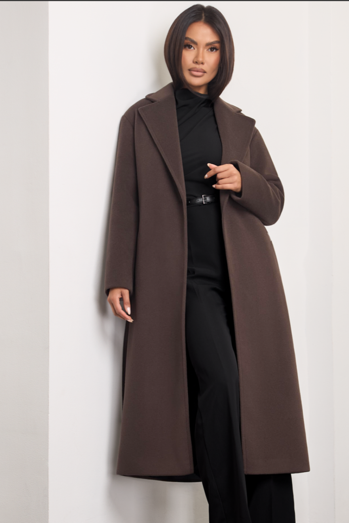 Brown wool coat Dakota for women – long elegant winter coat with wide lapels, belt at the waist, side pockets and dropped shoulders. Insulated and lined, warm and timeless. Model is wearing XS size. Rudas vilnonis paltas Dakota – ilgas, klasikinio silueto paltas su diržu, kišenėmis ir nuleistais pečiais.