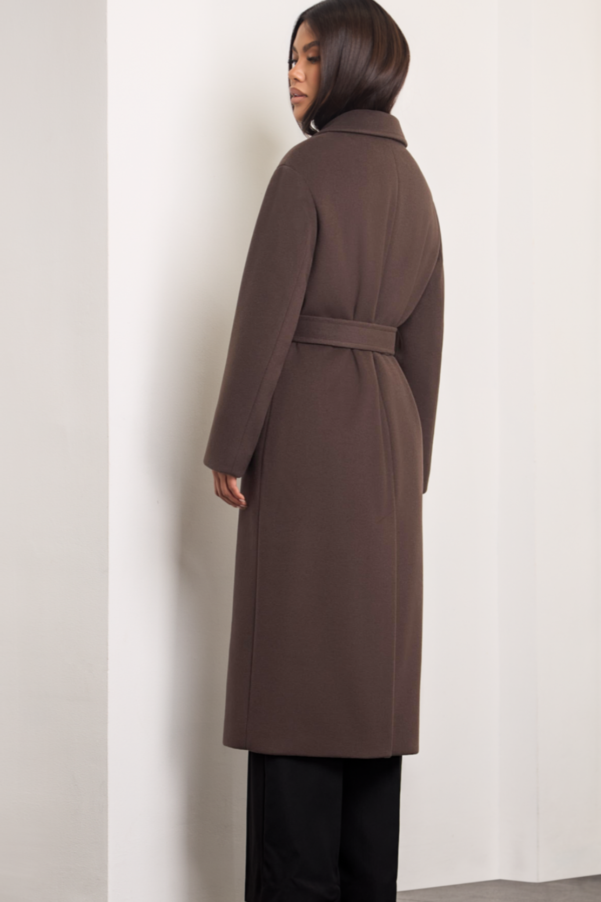 Brown wool coat Dakota for women – long elegant winter coat with wide lapels, belt at the waist, side pockets and dropped shoulders. Insulated and lined, warm and timeless. Model is wearing XS size. Rudas vilnonis paltas Dakota – ilgas, klasikinio silueto paltas su diržu, kišenėmis ir nuleistais pečiais.