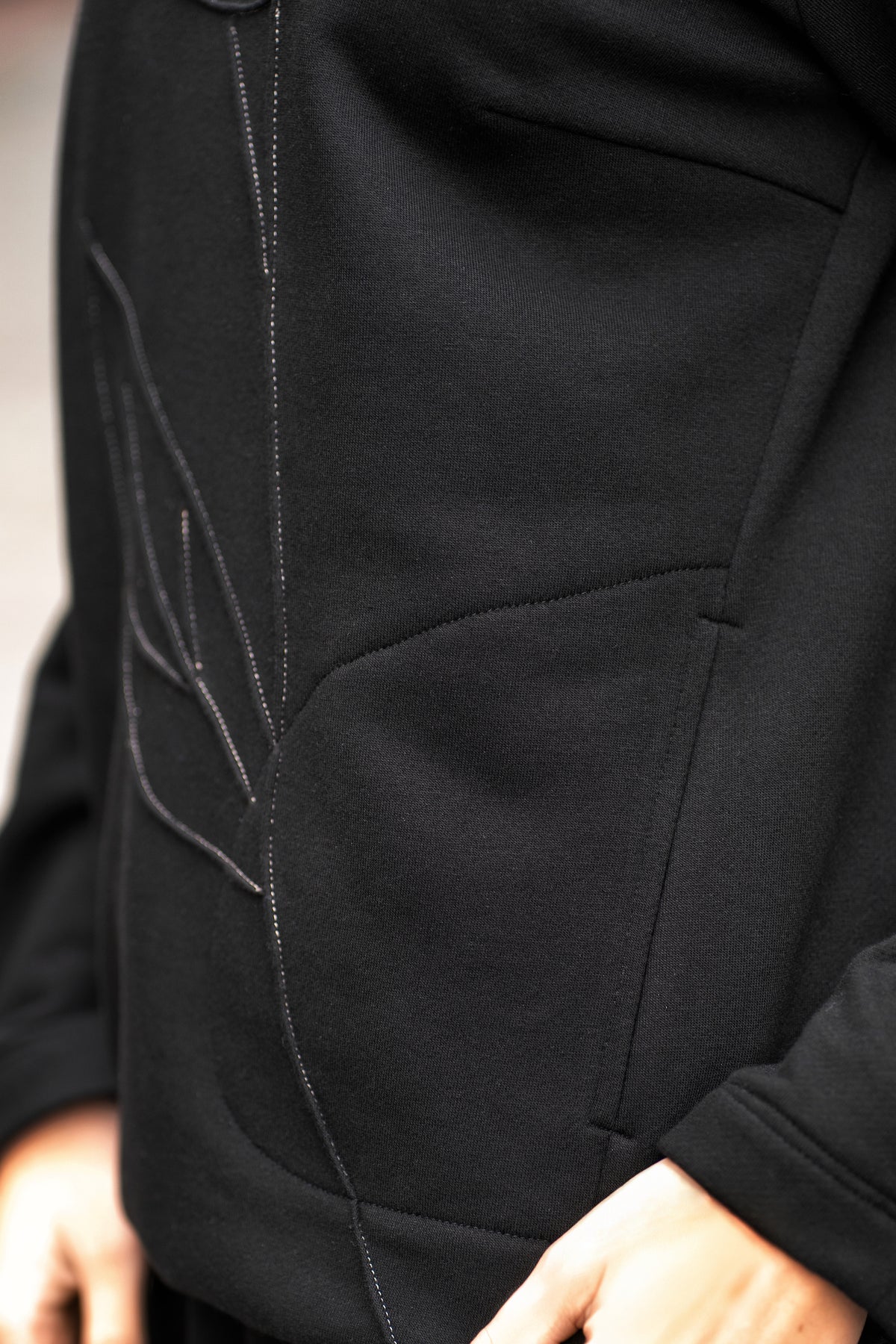 Džemperio priekio detalė su siuvinėta rože, tono prie tono siūlai, subtilus dekoras.
Close-up of the embroidered rose detail on the front of the sweatshirt, tone-on-tone stitching for an elegant look.