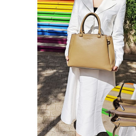 Taupe genuine leather handbag for women, elegant and spacious design with silver details, worn by model in white outfit.
Taupe spalvos natūralios odos rankinė moterims, elegantiško ir talpaus dizaino su sidabro detalėmis, modelis su balta suknele.