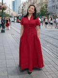 Vyšnių spalvos ilga lininė suknelė su sagomis ir kišenėmis, laisvo silueto, lengvai platėjanti, moteris stovi miesto gatvėje, elegantiškas ir patogus vasaros įvaizdis, natūralus kvėpuojantis audinys, Cherry color long linen dress with buttons and pockets, relaxed fit flowing silhouette, woman standing in city street, breathable natural fabric elegant and comfortable summer outfit