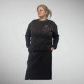 Warm thick-knit two-piece women’s set with a straight skirt (80 cm), long-sleeve sweatshirt (65 cm), handmade flower applique, pockets in both pieces, elastic waist, side slits on the skirt, comfortable fit, sizes 36–52. Šiltas storas trikotažinis kostiumėlis su sijonu ir džemperiu, kišenėmis, gumos įsiuvais, skeltukais ir rankų darbo gėle, dydžiai 36–52.