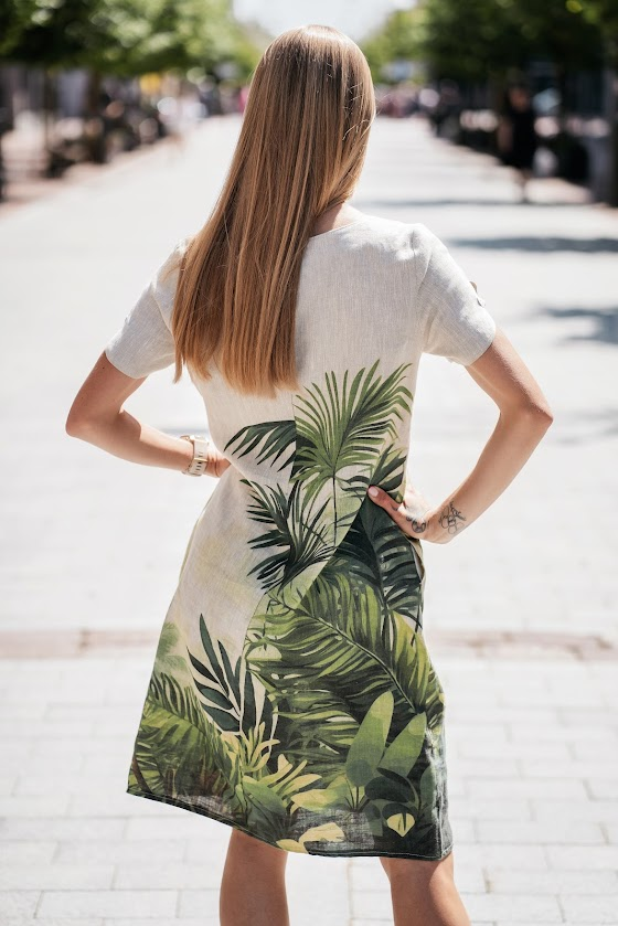 Model wearing a natural linen dress with a relaxed silhouette and side pockets, made from softened linen fabric, perfect for warm summer days. The model is 173 cm tall and wears size 40. Suknelė pasiūta Lietuvoje iš 100 % lino – lengva, elegantiška ir kvėpuojanti.