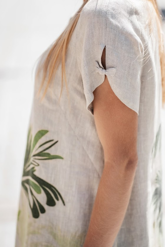 Model wearing a natural linen dress with a relaxed silhouette and side pockets, made from softened linen fabric, perfect for warm summer days. The model is 173 cm tall and wears size 40. Suknelė pasiūta Lietuvoje iš 100 % lino – lengva, elegantiška ir kvėpuojanti.