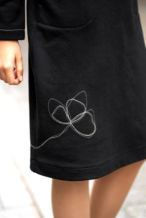 Juodos trikotažinės suknelės šoninė kišenė su kontrastinėmis siūlėmis – black knit dress side pocket detail with decorative stitching