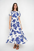 Blue floral maxi dress made of linen and viscose, lightweight breathable summer dress with short puff sleeves, elastic back waist, elegant loose silhouette, long flowing dress with pockets, comfortable natural fabric, feminine casual vacation outfit, mėlyna ilga suknelė su gėlių raštu, lengva vasarinė suknelė su kišenėmis, kvėpuojantis lino ir viskozės audinys, moteriškas siluetas kasdienai ir atostogoms